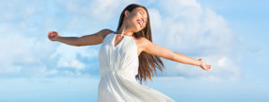 Woman joyfully embracing freedom after arm lift surgery at Lentz Plastic Surgery.