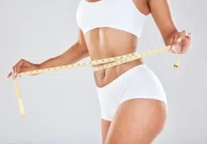 Woman measuring waist, symbolizing effective medical weight loss solutions.