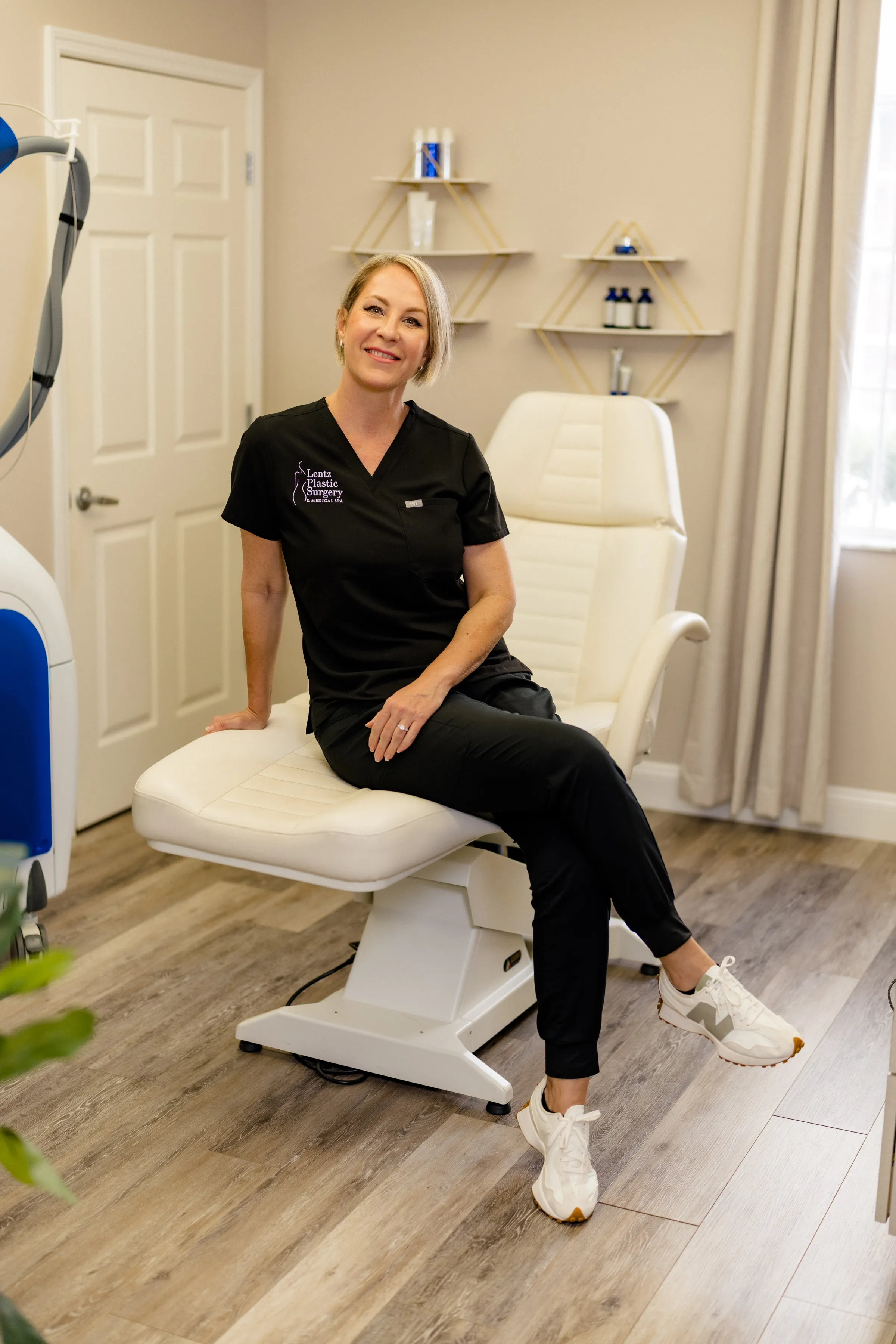 Judit a Professional aesthetician in black scrubs sitting at an aesthetic clinic.